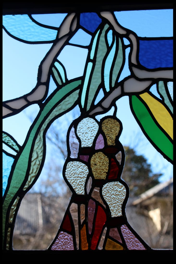 Australian Native leadlight &mdash; angophora branches and gumnuts in coloured glass, a Wentworth Falls garden and house seen through the panel