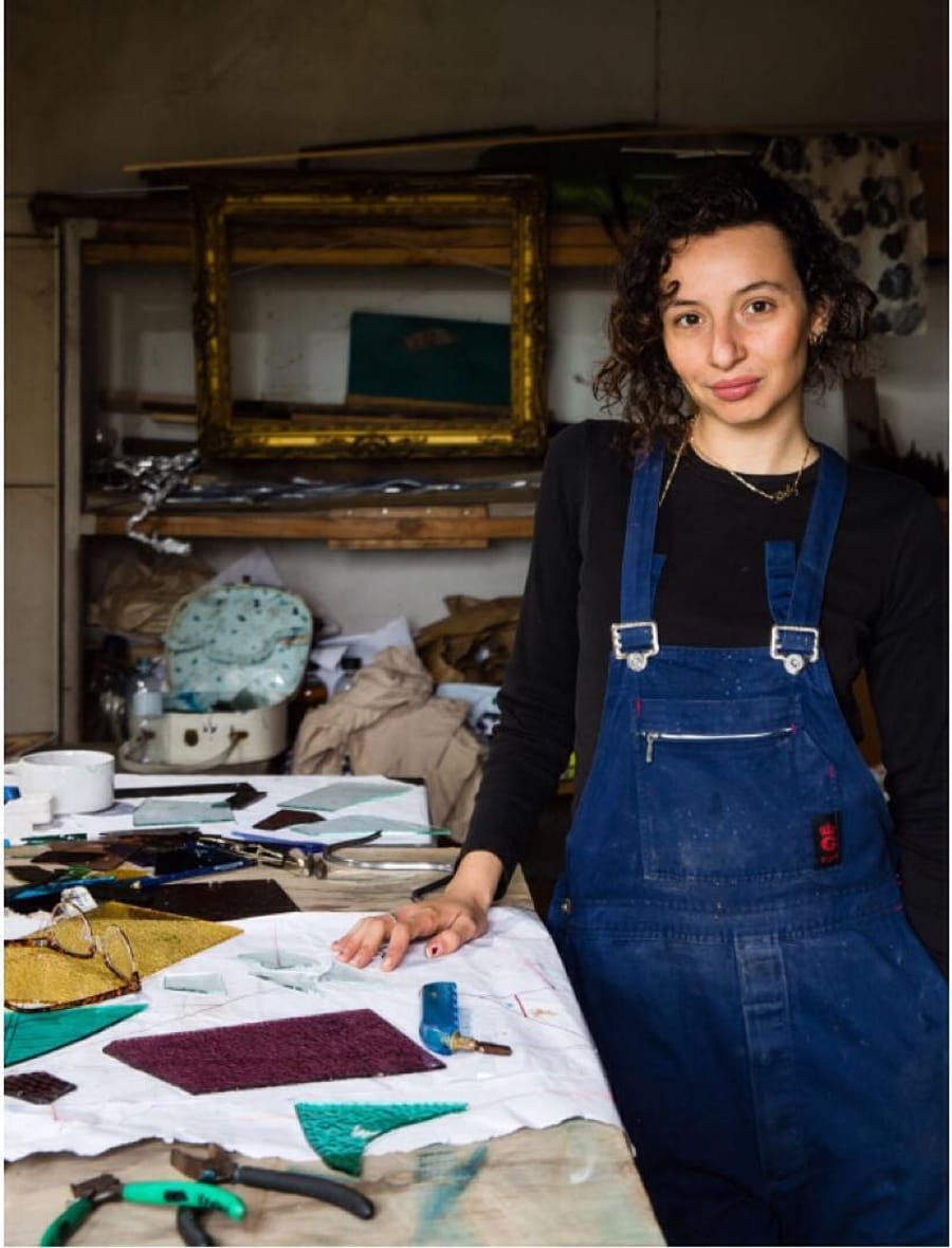 Kirby Sharrock in her Blue Mountains workshop, at a bench laid with cut coloured glass