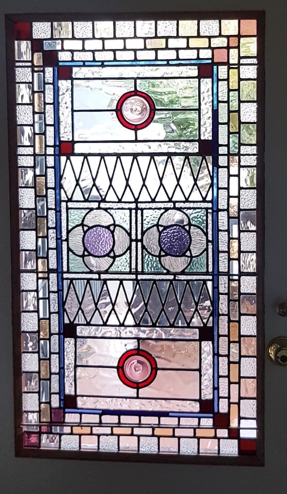 Modern geometric leadlight panel with a green hexagon, red triangle and yellow circle