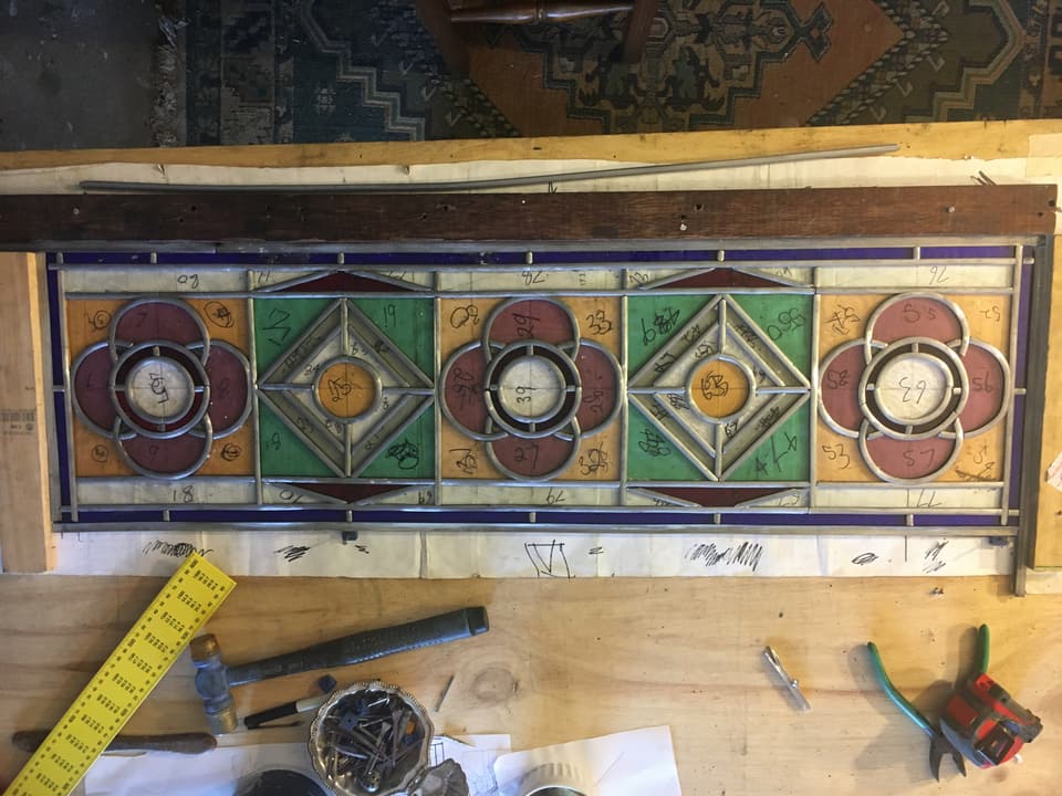 Victorian flower medallion panel on the studio bench, red and green roundels