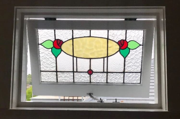 Federation highlight window with a central amber oval, red roses and green leaves, set in a white frame