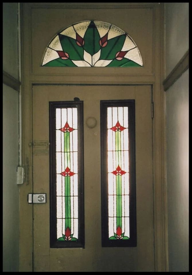 Federation front door with an arched fanlight in a green deco-leaf sunburst above two tulip sidelight panels