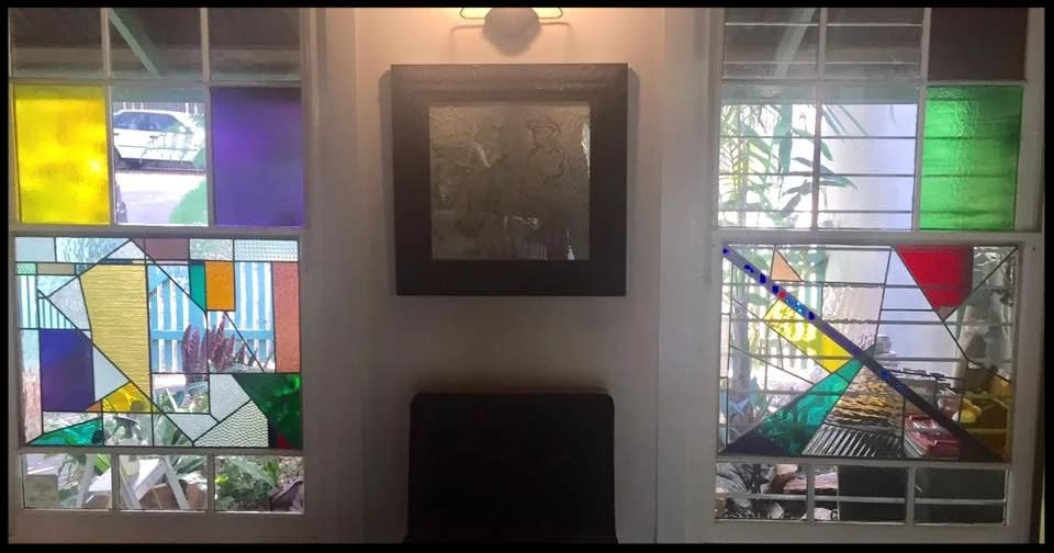 Modern leadlight windows in an interior, blocks of primary colour flanking a framed picture